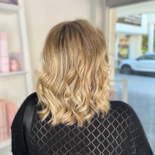 Shoulder-length blonde hair styled in soft waves